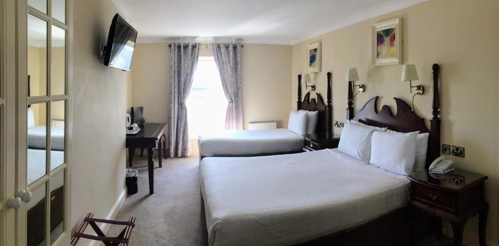 Postel nebo postele na pokoji v ubytování Shamrock Inn Hotel