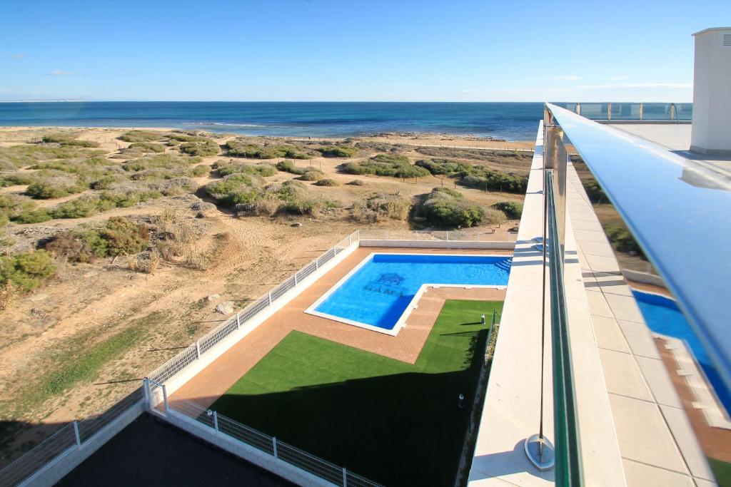 an overhead view of a swimming pool on a building with the ocean at Alex Sun in La Mata