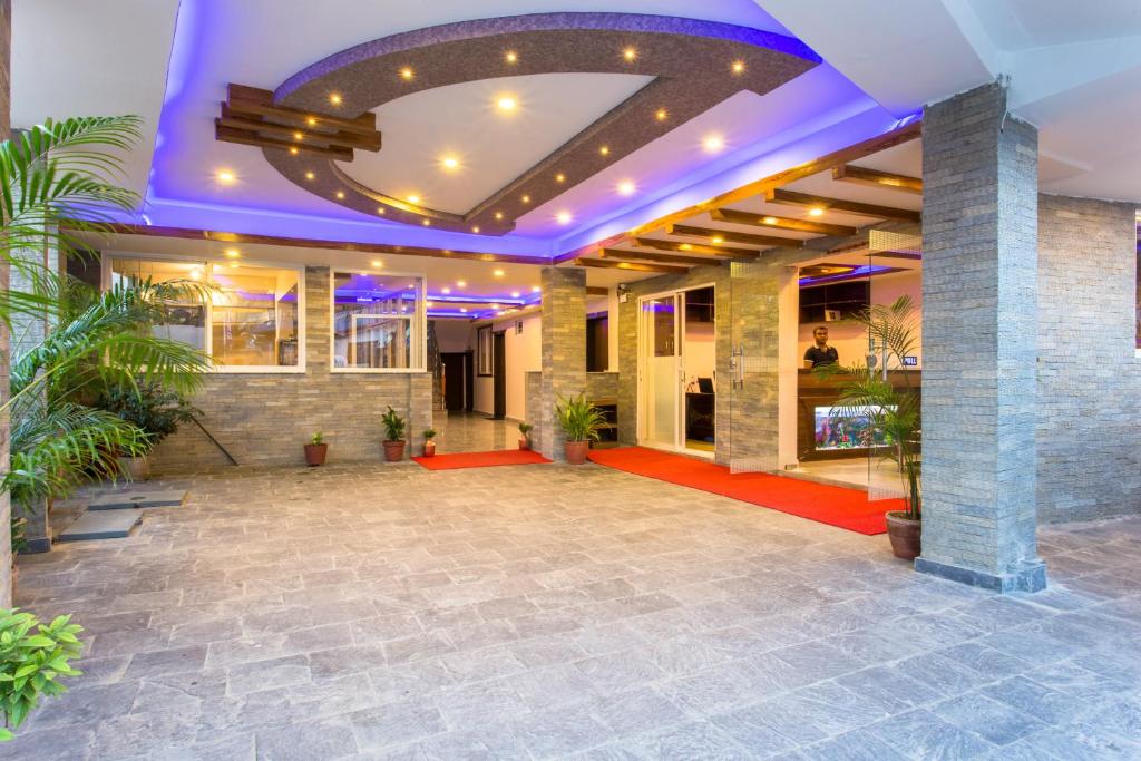 eine große Lobby mit lila Beleuchtung und Pflanzen in der Unterkunft Hotel Beijing Lu in Pokhara