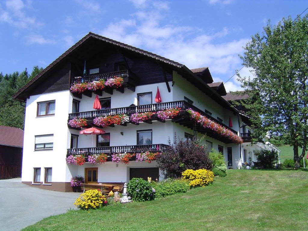 a white house with flowers on the side of it at Gästehaus Penzkofer F**** in Viechtach