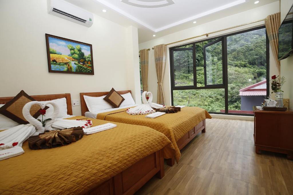 Habitación de hotel con 2 camas y ventana en Hoang Phuc Hotel Cat Ba en Cat Ba