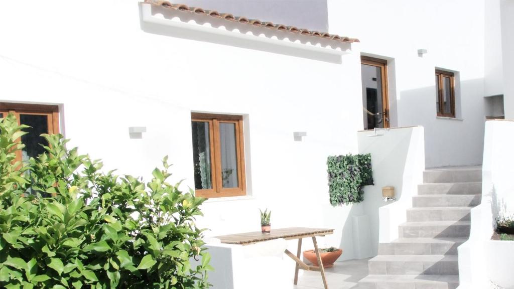 アルジェズールにあるCasa D' Avó Bia - Renovated Houseの階段とテーブルのある白い家