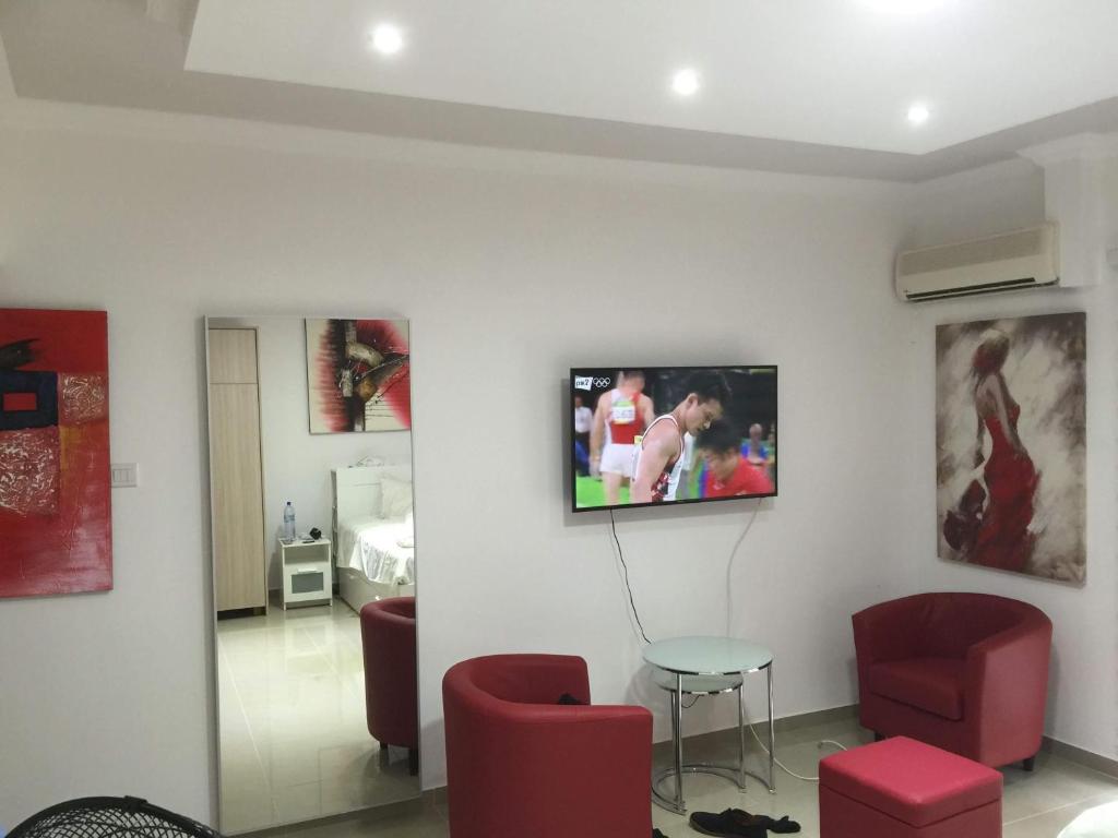 a living room with a tv on a wall at Paphos gardens studio suite in Paphos