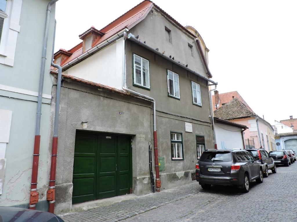 un bâtiment avec une porte verte dans une rue dans l'établissement Musik Apartments Old Town, à Sibiu