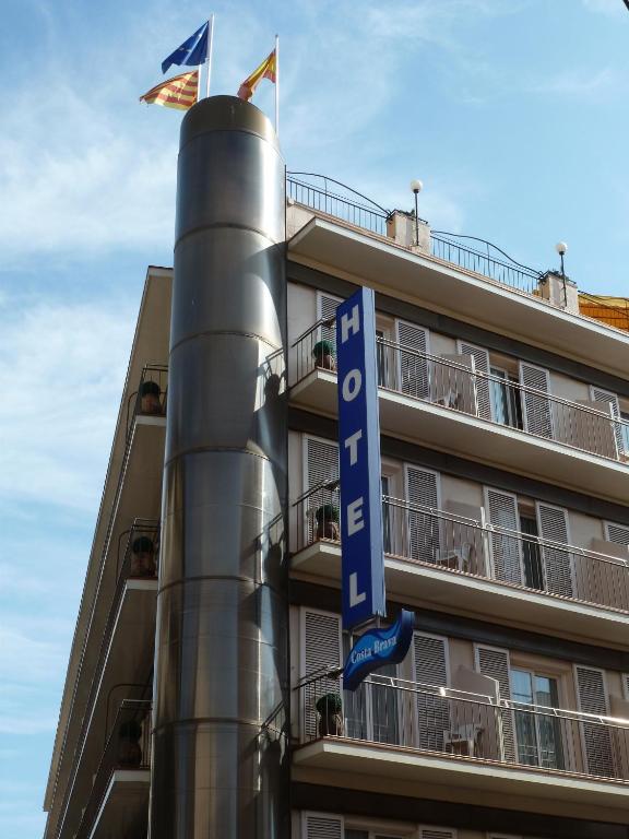 a hotel with a sign on a pole next to a building at Hotel Costa Brava in Blanes