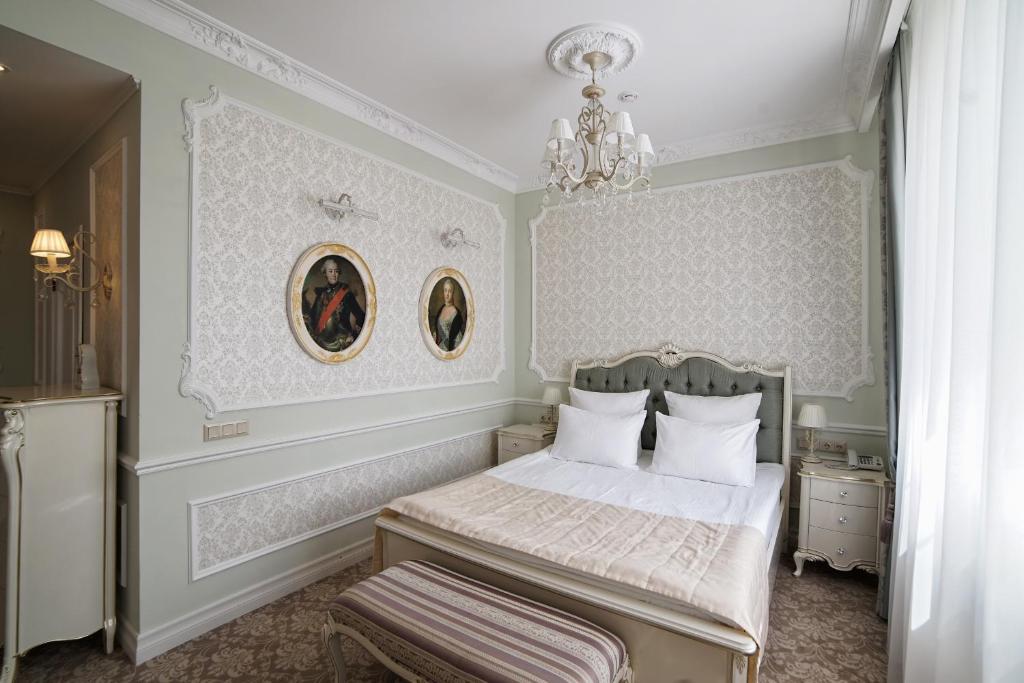 a bedroom with a bed and a chandelier at Hotel Ekaterina Kostroma in Kostroma