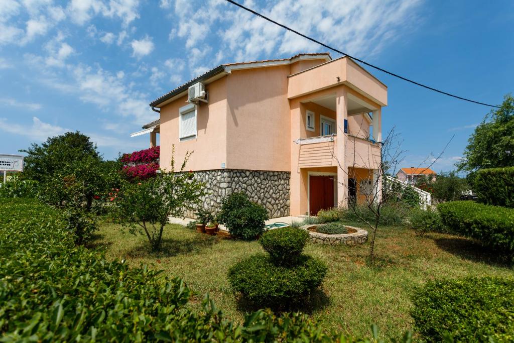 a house on a hill with a yard at Apartman Dobrila in Vrh