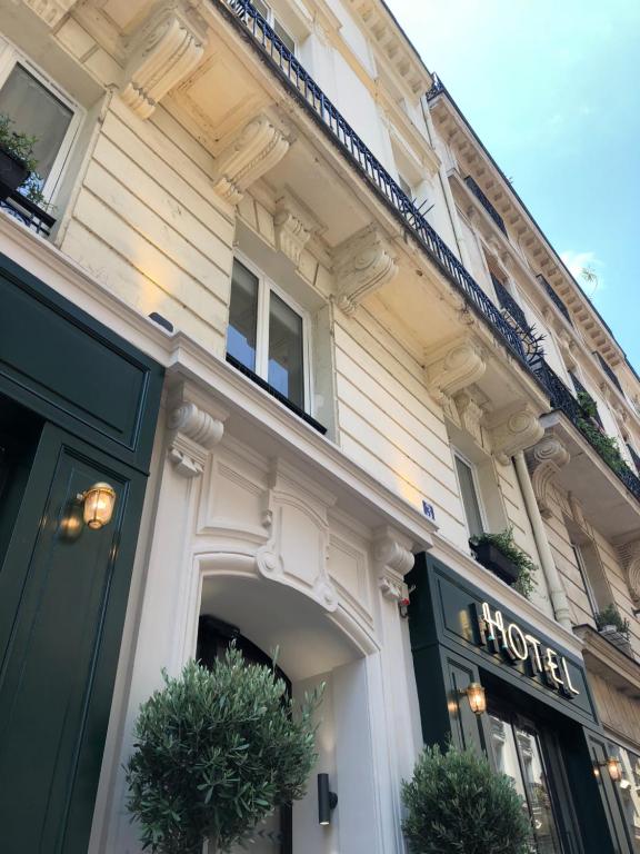 uma loja na frente de um edifício com plantas na porta em New Hotel Le Voltaire em Paris