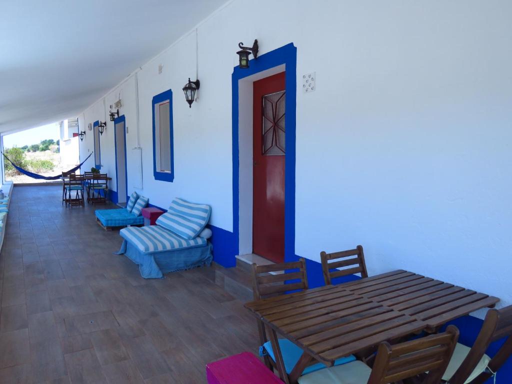 a dining room with blue walls and a wooden table and chairs at Vale do Boto-Quinta com 3 casas in Castro Marim