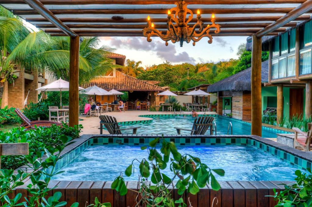 a swimming pool in a resort with a chandelier at Terra Boa Hotel Boutique in Itacaré