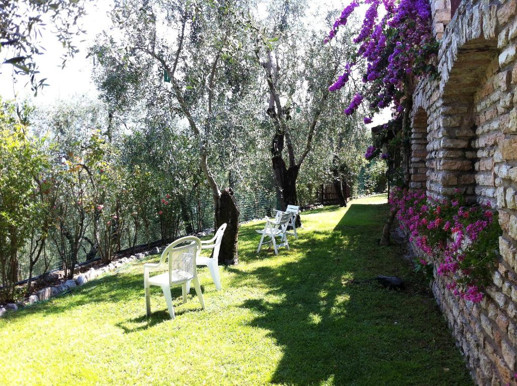 a row of white chairs sitting in the grass at Hotel Villa Margherita in Limone sul Garda