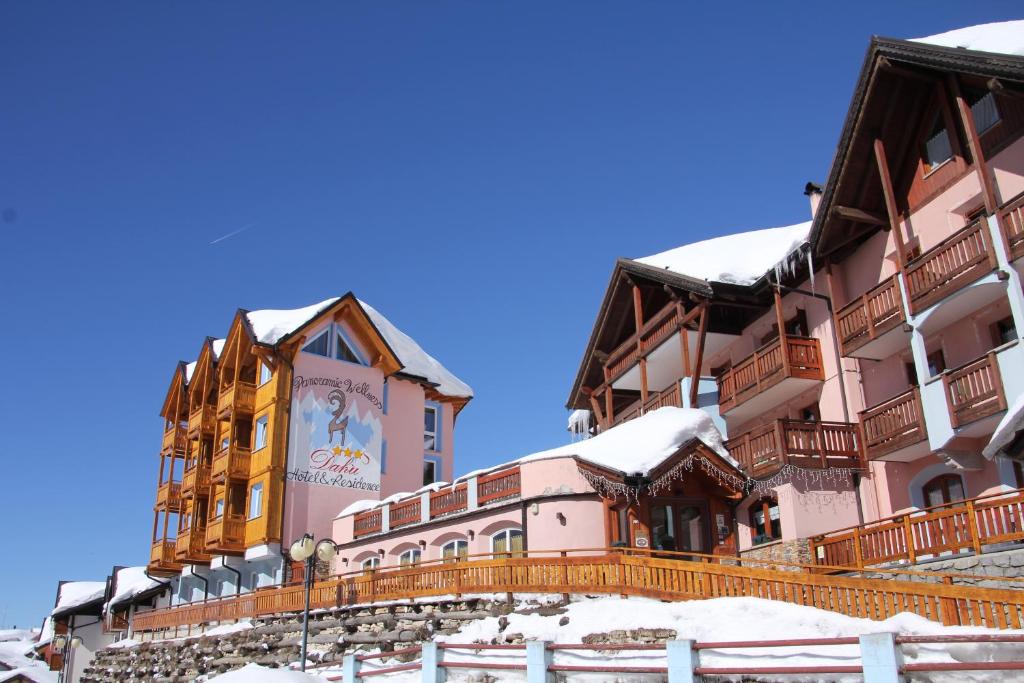 ein Gebäude mit einem Uhrturm im Schnee in der Unterkunft Hotel Residence Dahu in Passo del Tonale