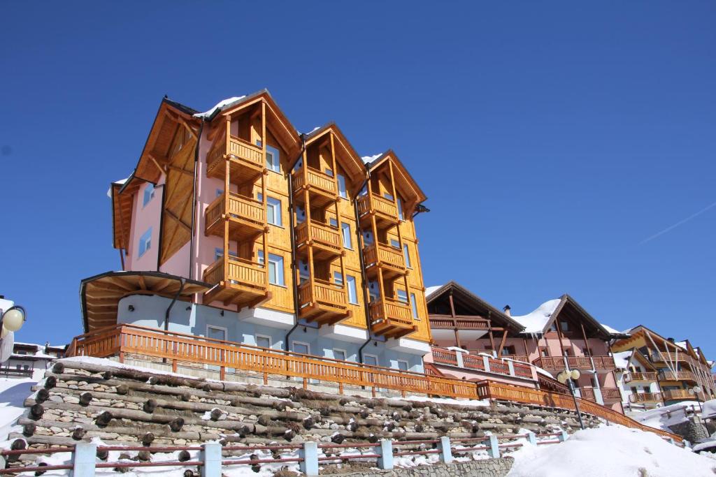 budynek z drewnianymi balkonami na szczycie góry w obiekcie Hotel Residence Dahu w mieście Passo del Tonale