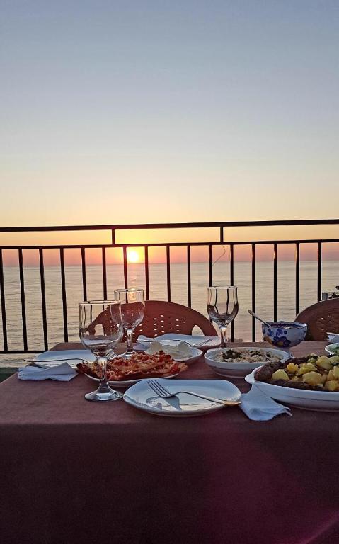a table with plates of food and wine glasses at Inn David in Chakvi