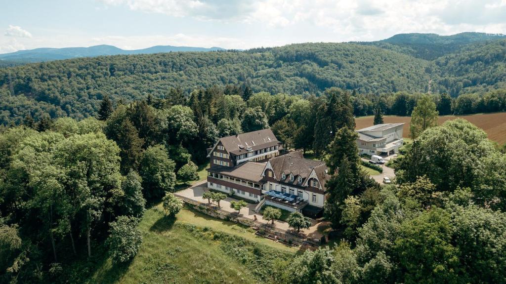 eine Luftansicht eines großen Hauses im Wald in der Unterkunft Bienenberg - Das Genusshotel im Grünen - Liestal in Liestal