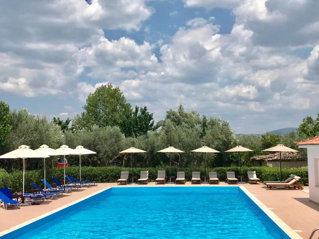 einen Pool in einem Resort mit Stühlen und Sonnenschirmen in der Unterkunft Castle View Bungalows in Mystras