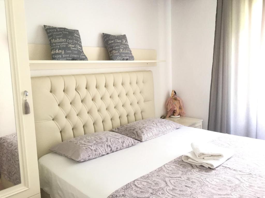 a bed with a white headboard in a bedroom at Sweet Rooms Kavala in Kavála