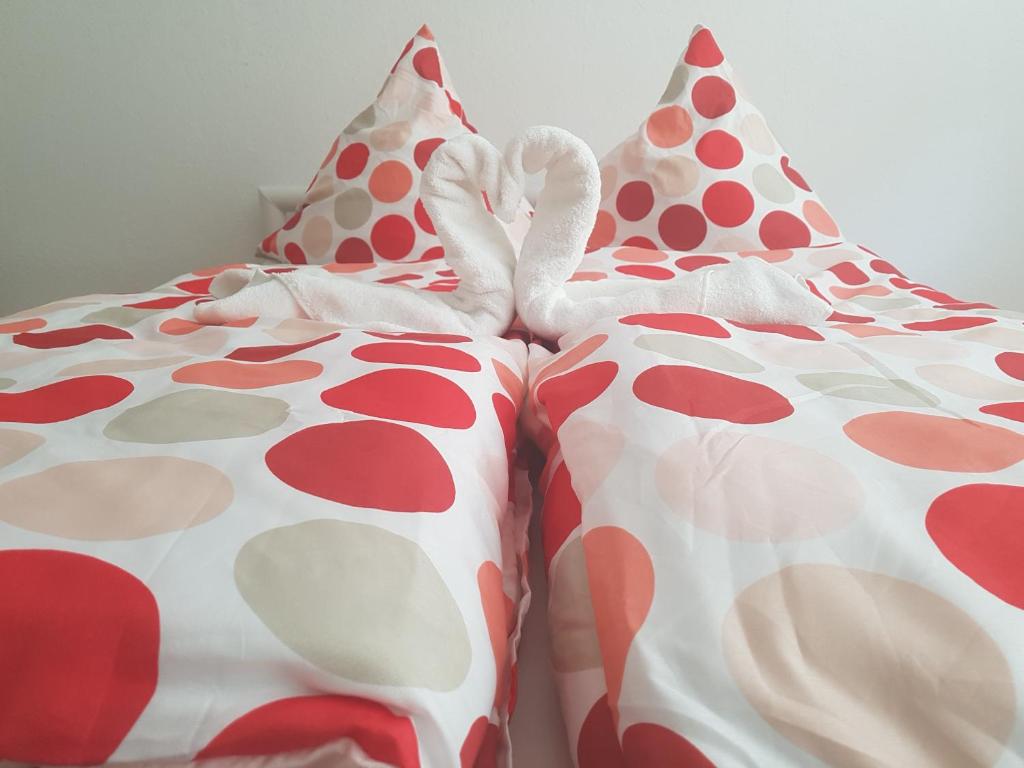 a bed with red and white polka dot sheets at Ferienwohnung im Mühlbachtal in Miehlen