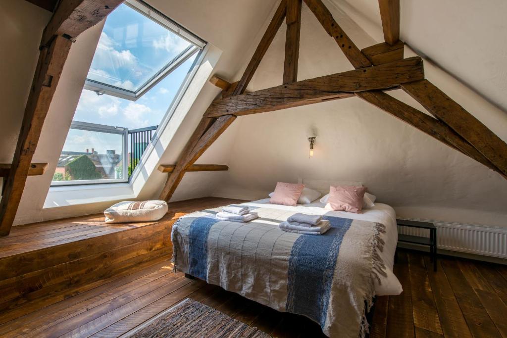 a bedroom with a bed and a large window at Friday Gent in Ghent