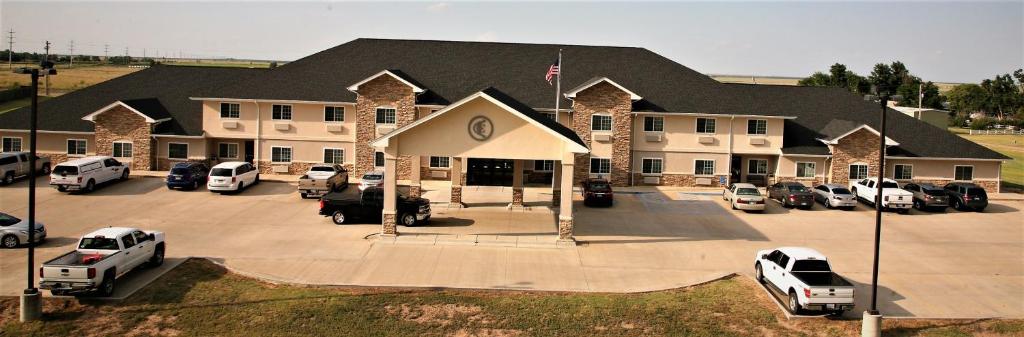 a large building with cars parked in a parking lot at Corporate East Hotel in Ulysses