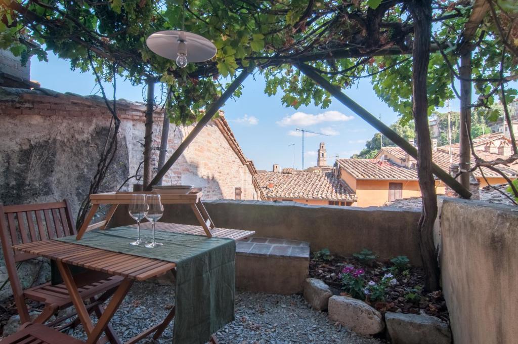 a wooden bench sitting under an umbrella on a patio at La Casa dei Pellari in Perugia