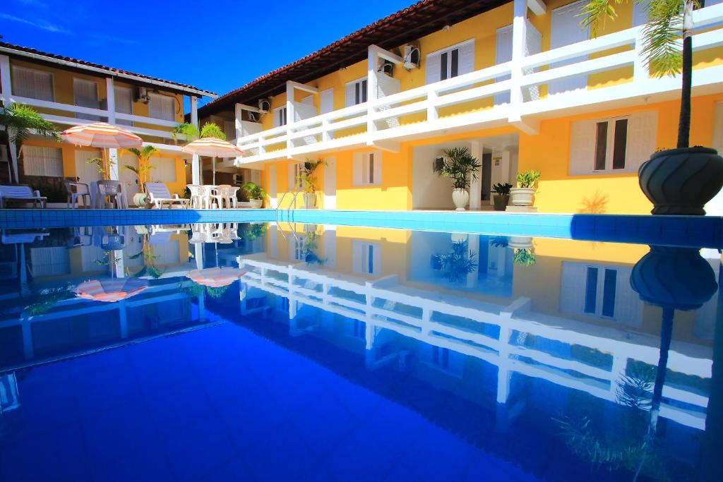 a swimming pool in front of a hotel at Navegantes Hotel in Porto Seguro