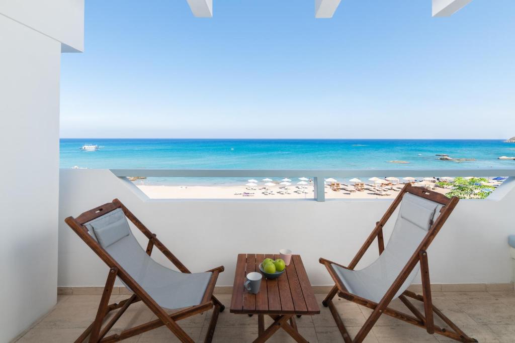 duas cadeiras e uma mesa com vista para o oceano em Stegna Akti Luxury Suites em Archangelos