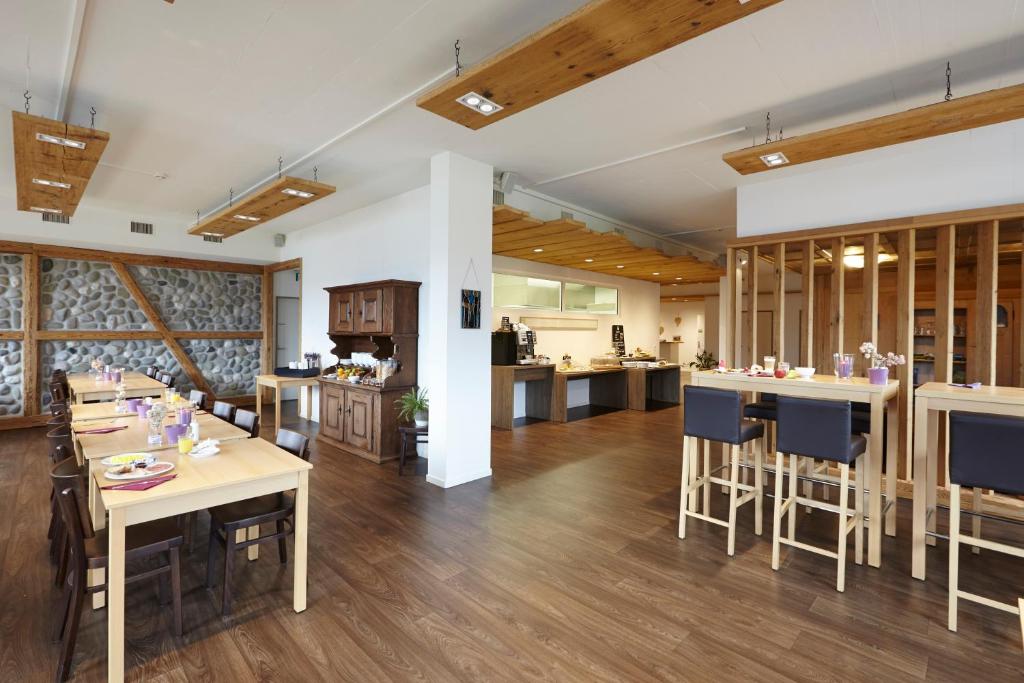 une chambre avec des tables et des chaises ainsi qu'une cuisine dans l'établissement B&B Hotel Peter und Paul, à Willisau