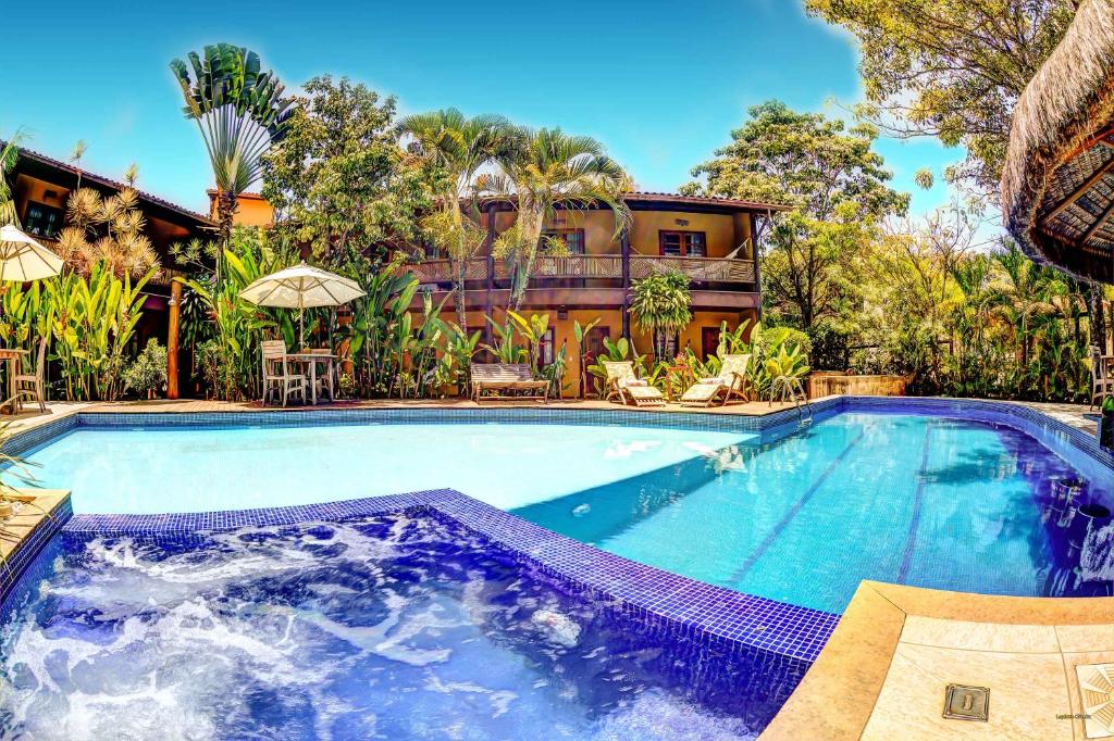 a large swimming pool in front of a house at Pousada Pedra Torta in Itacaré