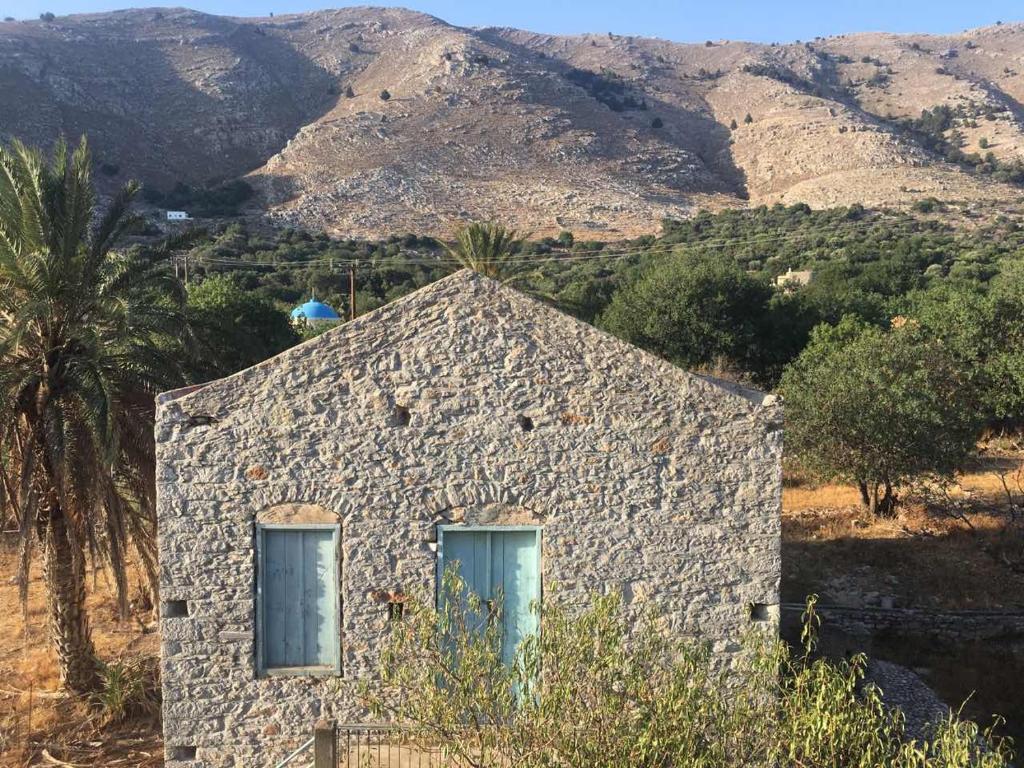 a stone building with two windows on a mountain at "STELIOS & GALINI" in Symi