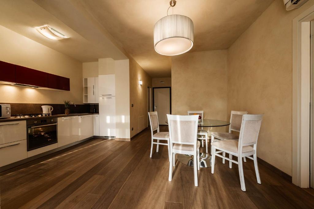 una cucina e una sala da pranzo con tavolo e sedie di Maison La Scala Luxury solution Lazise Center a Lazise