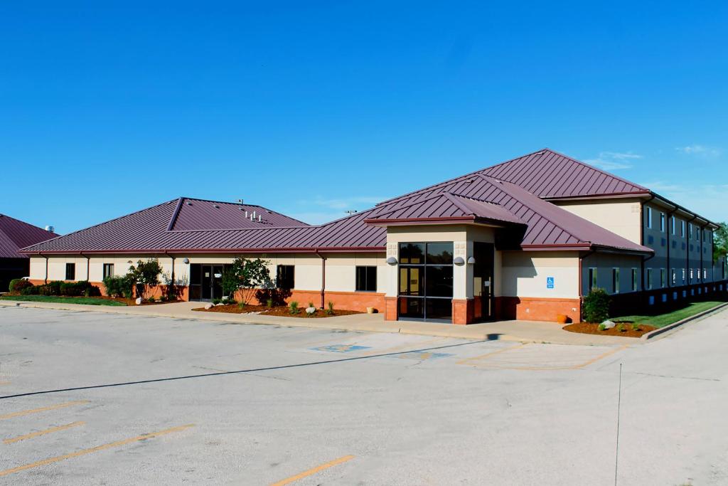 a large building with a red roof on a street at Americas Best Value Inn-Fredonia in Fredonia