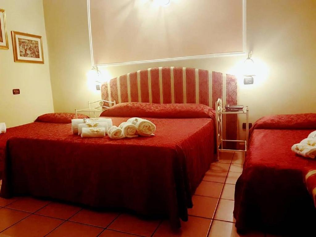 a hotel room with two beds with towels on them at Hotel Sicilia in Milan