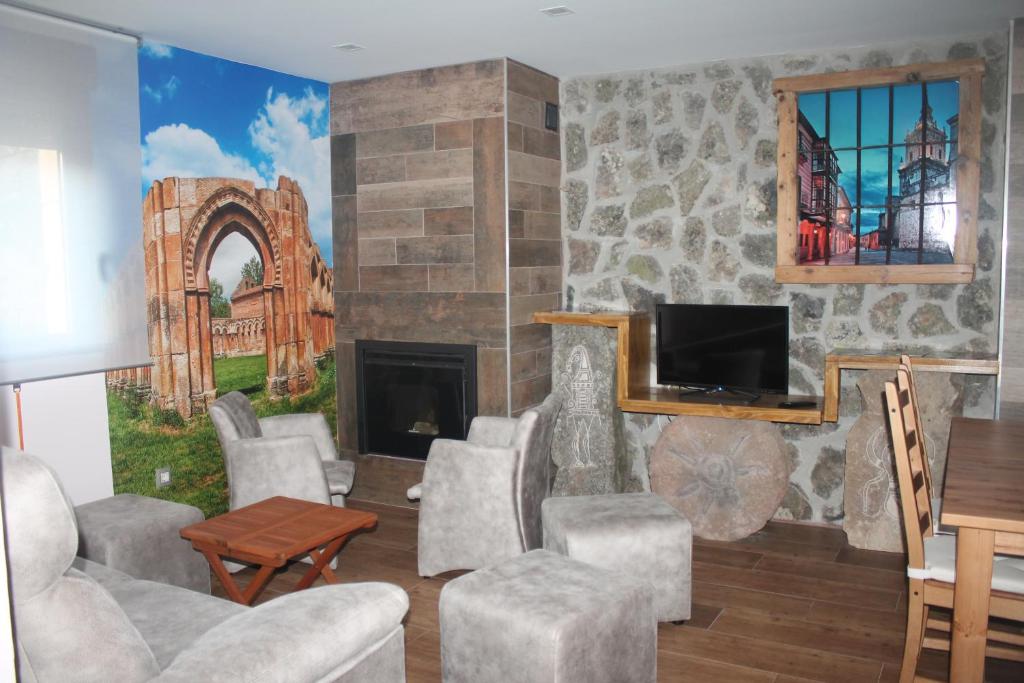 sala de estar con chimenea y TV en Apartamentos Numancia, en Garray