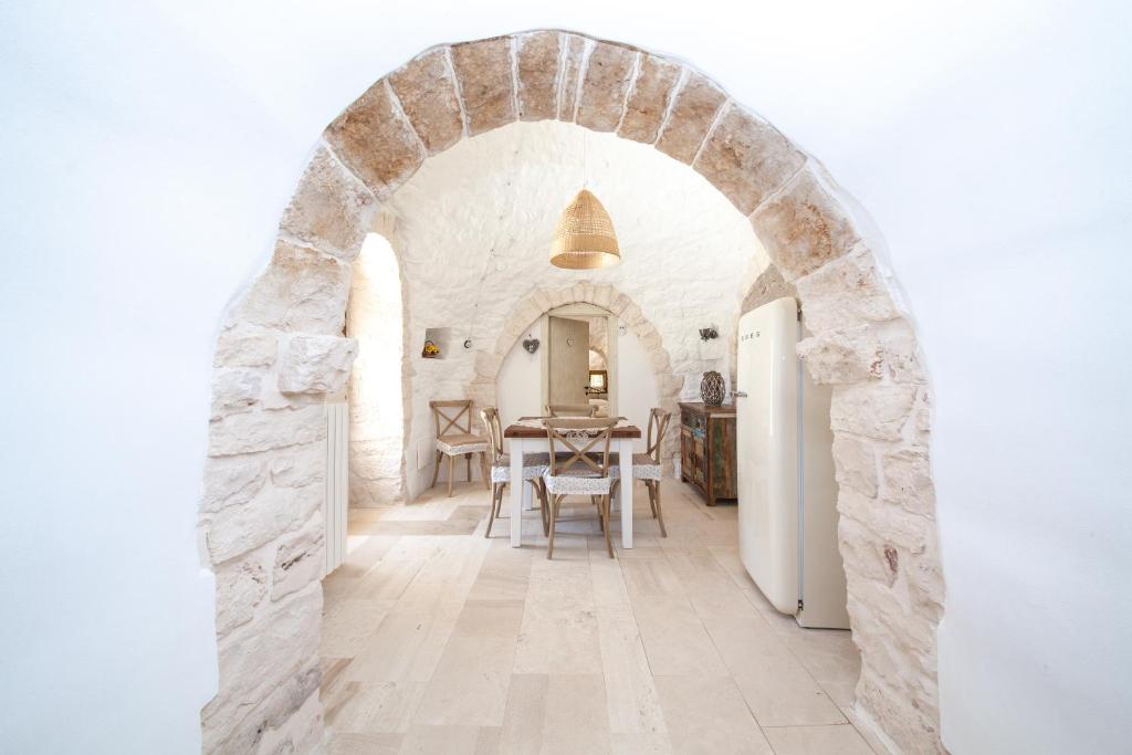 une arche dans une cuisine avec une table et des chaises dans l'établissement Trullo Siamese, à Alberobello