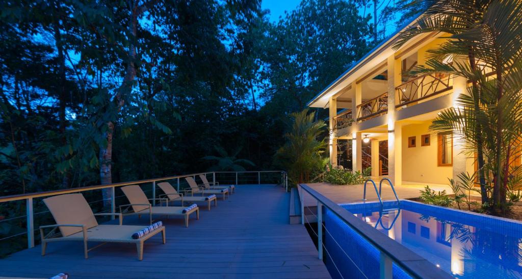 une maison avec une terrasse dotée de chaises et une piscine dans l'établissement Casa Monos Locos - Portasol Vacation Rentals, à Portalón
