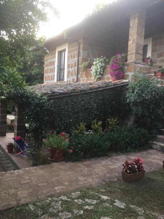 dom z roślinami i kwiatami przed nim w obiekcie Agriturismo Casale Loreto w mieście Corchiano