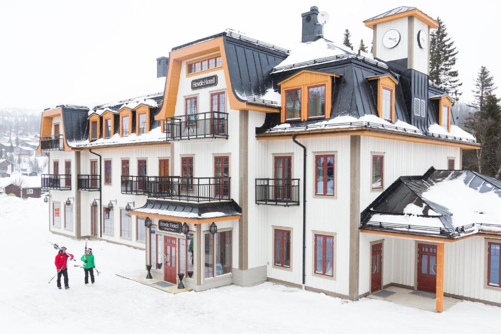 eine Gruppe von Menschen, die im Schnee vor einem Gebäude stehen in der Unterkunft Hovde Hotell in Vemdalsskalet