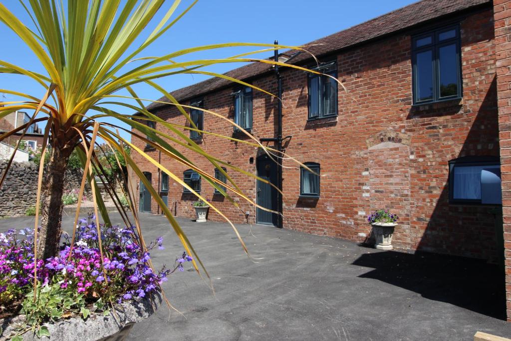 un bâtiment en briques avec un palmier devant lui dans l'établissement 2 Fox Studios, à Much Wenlock