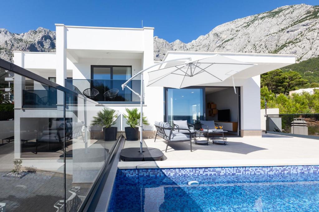 a white villa with a swimming pool at Villa MirA with fantastic sea view in Makarska