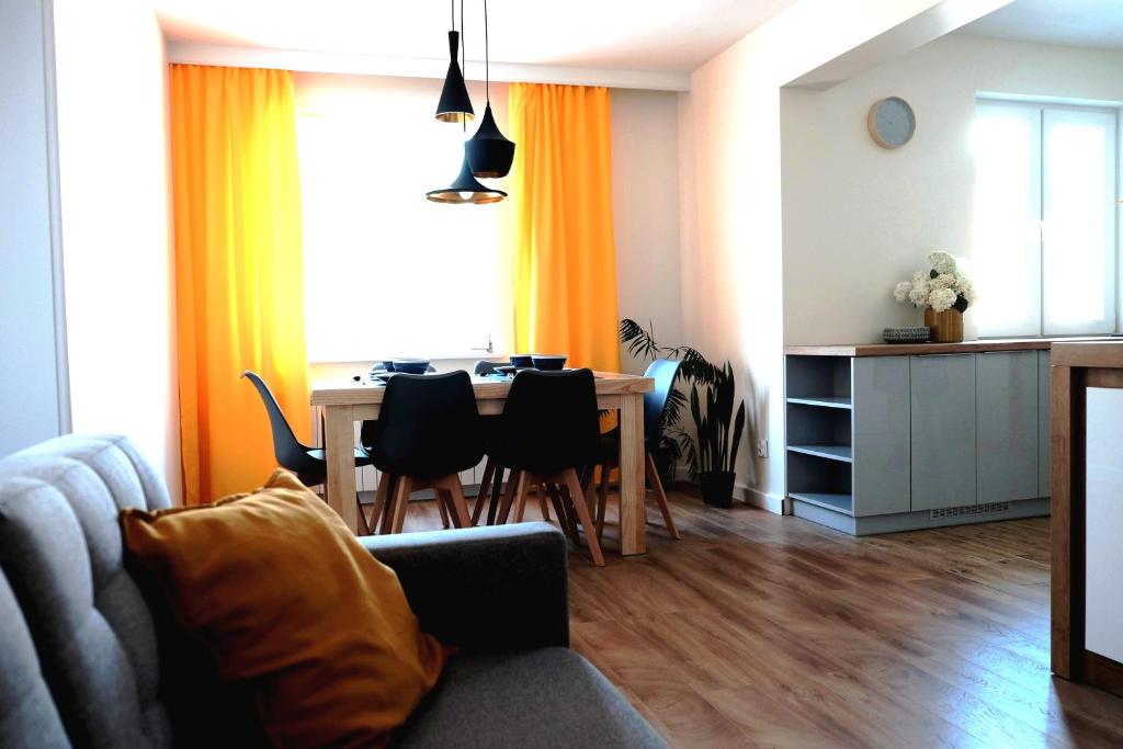 a living room with a table and a dining room at Apartament Mieszczański in Sandomierz