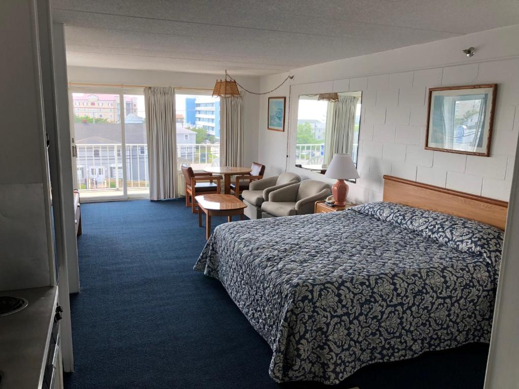 Habitación de hotel con cama y sala de estar. en Beachcomber Motel, en Ocean City