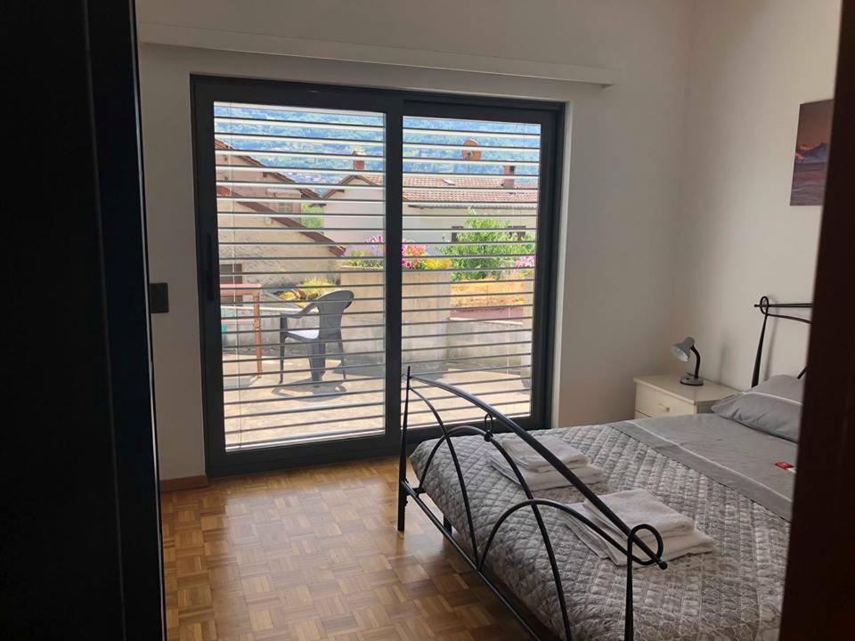 a bedroom with a bed and a door to a balcony at Casa Ines in Bellinzona