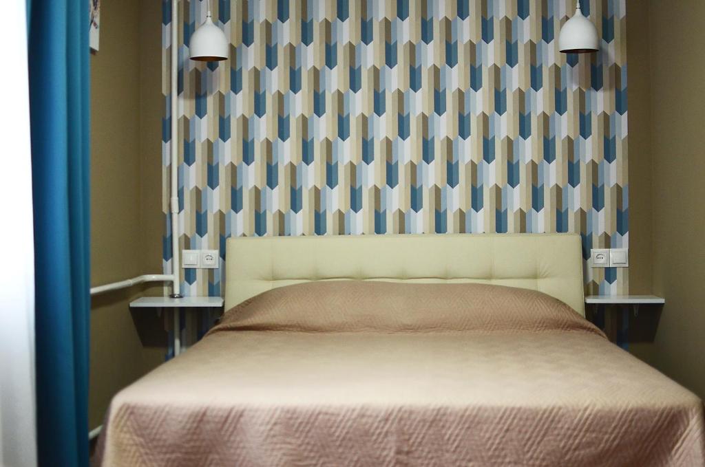 a bedroom with a bed with a checkered wall at Apartment near Megacenter in Chernihiv
