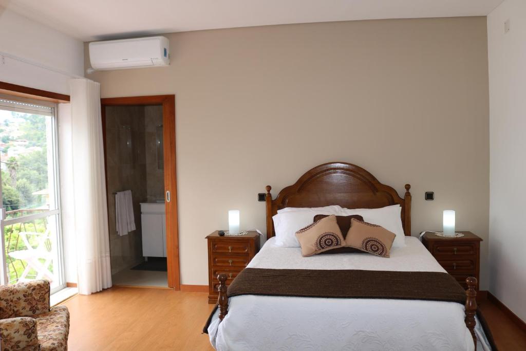1 dormitorio con 1 cama con 2 almohadas en Alojamento Correia, en Caldelas