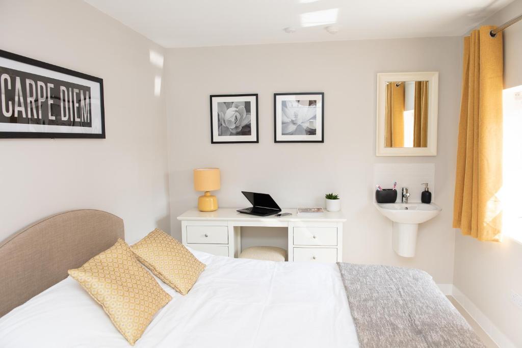 a white bedroom with a bed and a sink at Pinehill Rooms in Reading