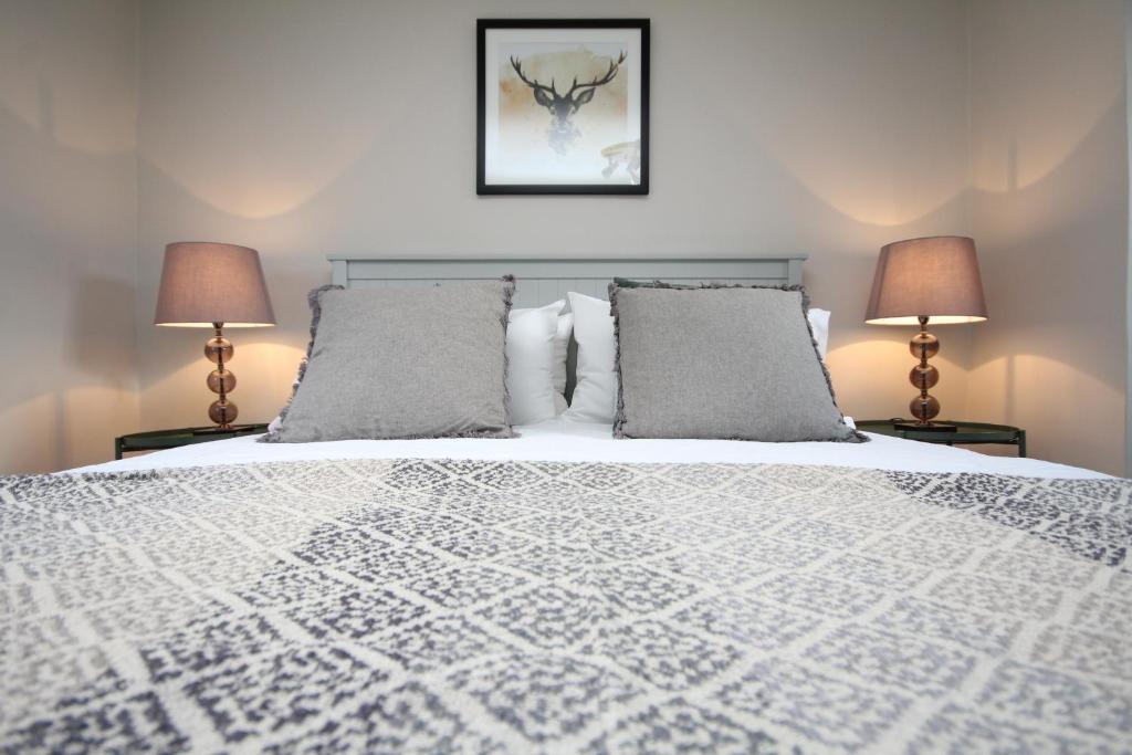 a bedroom with a large bed with two lamps at Malvern House in Banbury