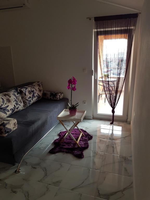 sala de estar con sofá, mesa y ventana en Studio Apartment Lili en Zadar