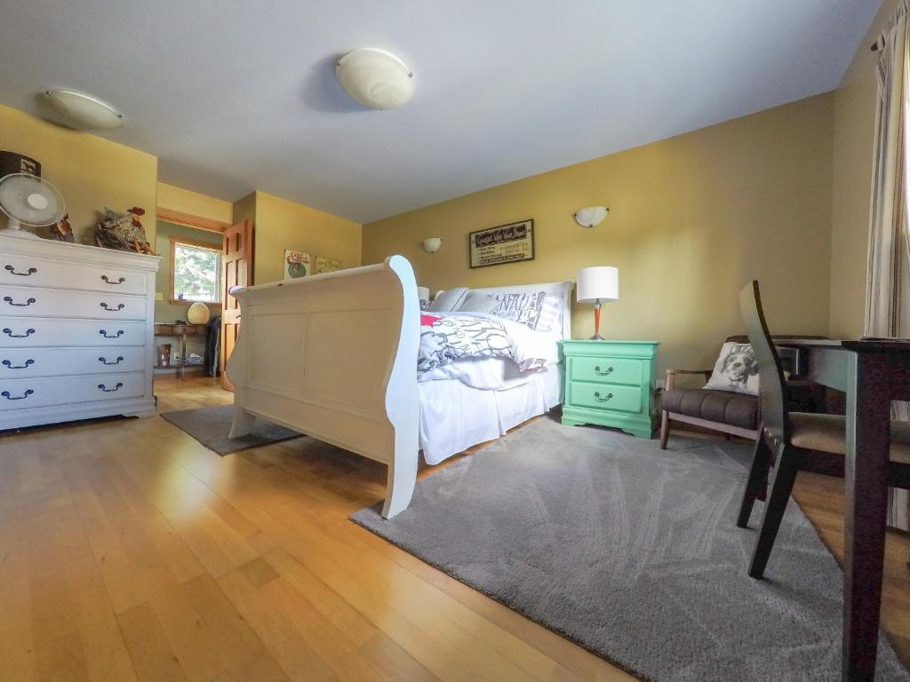 a bedroom with a bed and a dresser at Money Pennies Bed and Breakfast in Campbell River