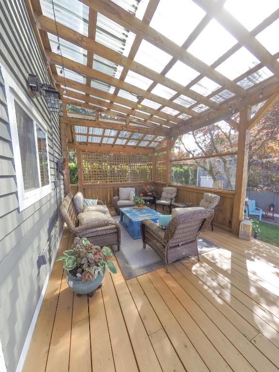 a pergola on a deck with furniture and a table at Money Pennies Bed and Breakfast in Campbell River